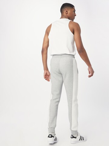 ADIDAS ORIGINALS Zwężany krój Spodnie 'Trefoil Essentials+ Reverse Material' w kolorze szary
