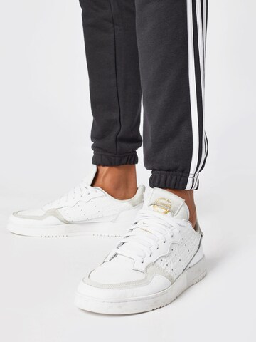 ADIDAS SPORTSWEAR Avsmalnet Sportsbukser 'Essentials French Terry Tapered 3-Stripes' i svart