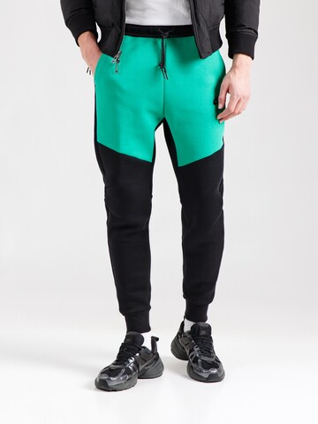 Tapered Pantaloni 'TCH FLC' de la Nike Sportswear pe negru: față