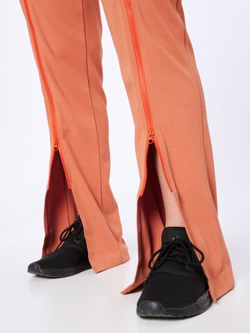 Flared Pantaloni sportivi 'Truecasuals ' di ADIDAS BY STELLA MCCARTNEY in arancione