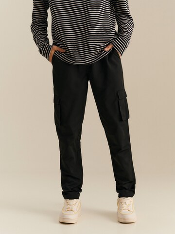 About You x Nils Kuesel Tapered Pants 'Iven' in Black