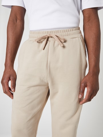ABOUT YOU x Louis Darcis Loose fit Trousers in Beige
