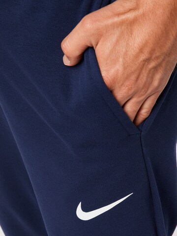 NIKE Tapered Sports trousers in Blue