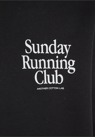 Bluză de molton 'Sunday Running Club' de la Another Cotton Lab pe negru
