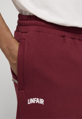 Tapered Pantaloni di Unfair Athletics in rosso