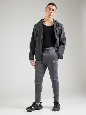 Tapered Pantaloni 'TCH FLC' de la Nike Sportswear pe gri