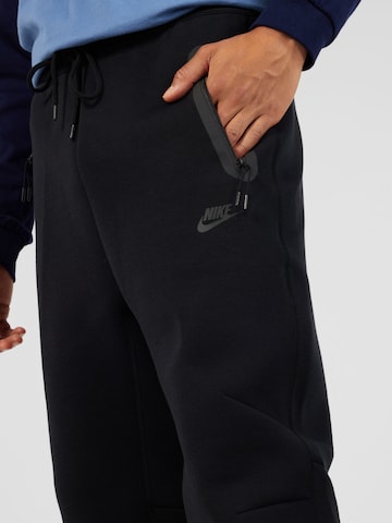 Nike Sportswear Loosefit Παντελόνι 'TECH FLEECE' σε μαύρο