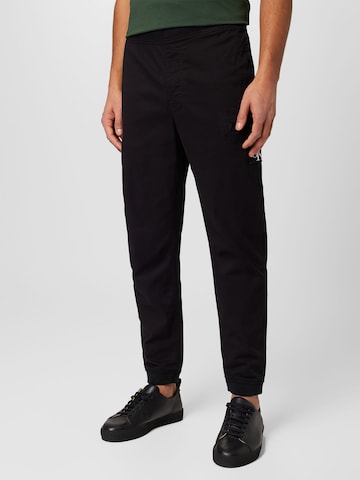 melns Calvin Klein Jeans Pakapēniski sašaurināts piegriezums Bikses: no priekšpuses