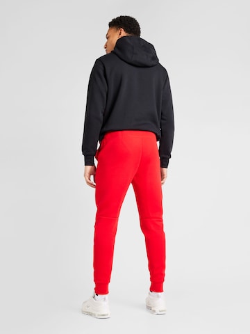 Nike Sportswear Tapered Byxa 'TCH FLEECE' i röd