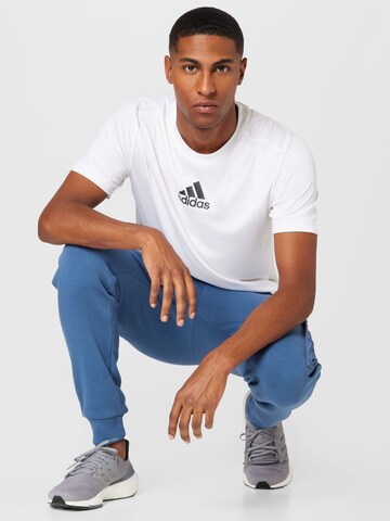 ADIDAS SPORTSWEAR Tapered Workout Pants 'Essentials Brandlove Fleece' in Blue