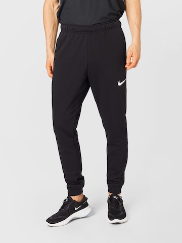 NIKE Tapered Sports trousers in Black: front