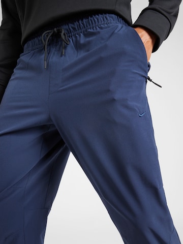NIKETapered Sportske hlače 'UNLIMITED' - plava boja