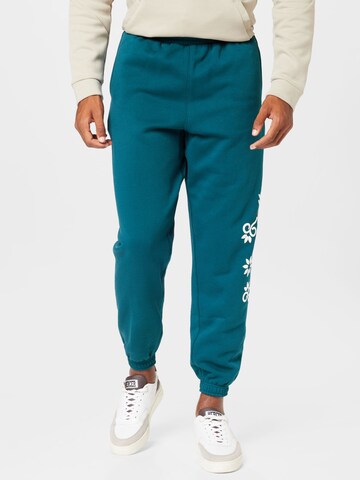 PUMA Tapered Sports trousers 'Run it Back' in Green: front