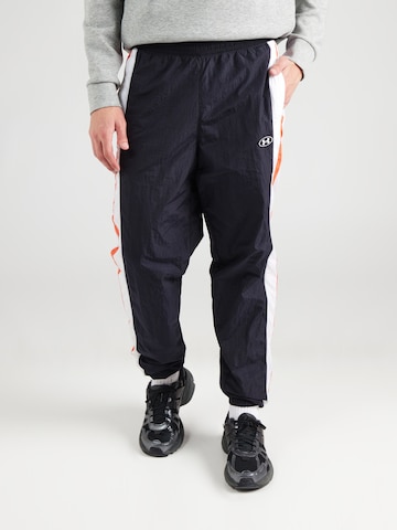 Effilé Pantalon de sport UNDER ARMOUR en noir : devant