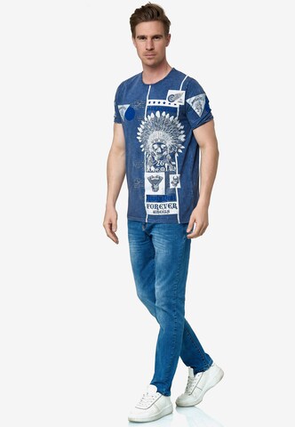Rusty Neal T-Shirt mit Oil Washed Skull All Over Front Print in Blau