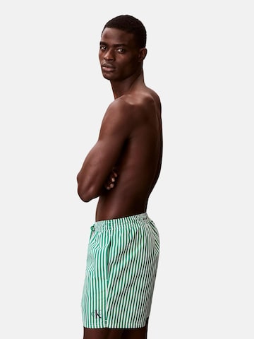 Calvin Klein Swimwear Uimashortsit 'CALVIN KLEIN MEDIUM DRAWSTRING Costumi da bagno' värissä vihreä