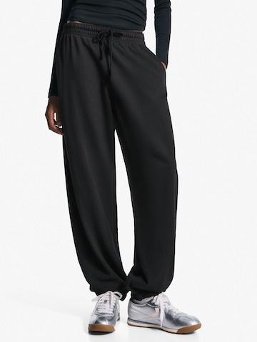 Bershka Дънки Tapered Leg Панталон в черно: отпред