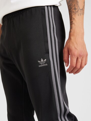 ADIDAS ORIGINALSTapered Hlače 'Adicolor' - crna boja