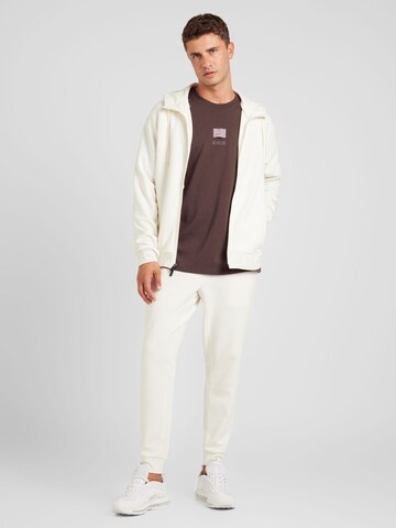NIKETapered Sportske hlače 'PRIMARY' - bež boja
