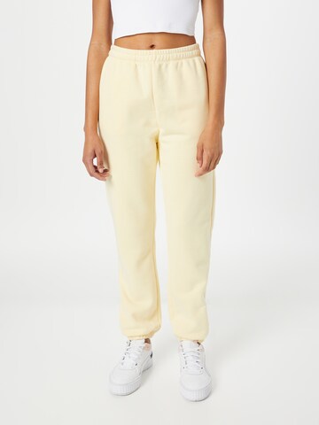 Champion Authentic Athletic Apparel - Tapered Pantalón en amarillo: frente