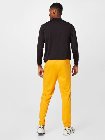 NIKE Zwężany krój Spodnie sportowe w kolorze żółty