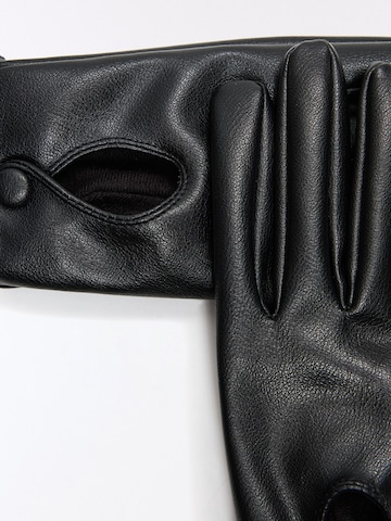 Gants Bershka en noir : au dessus