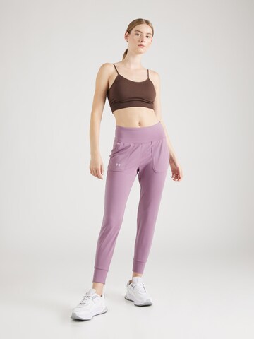 Effilé Pantalon de sport 'Motion' UNDER ARMOUR en violet