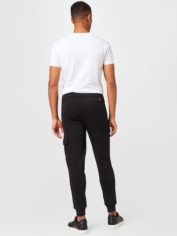 Calvin Klein Jeans تابيرد سراويل الحمولة بلون أسود