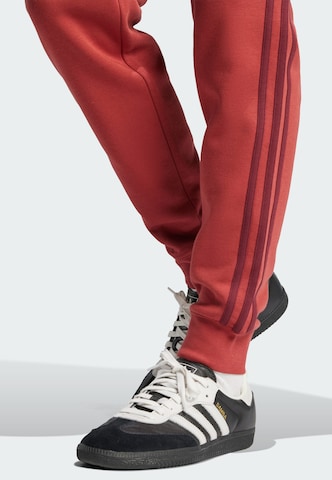 ADIDAS ORIGINALS - Tapered Pantalón 'Adicolor' en rojo