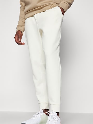 NIKE Tapered Sports trousers 'PRIMARY' in Beige