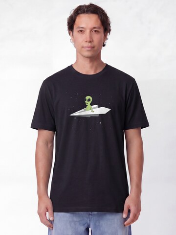 Maglietta 'Alien On A Paper Plane' di Watapparel in nero: frontale