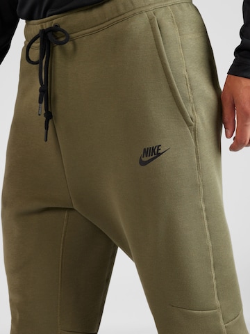 zaļš Nike Sportswear Pakapēniski sašaurināts piegriezums Bikses 'TECH FLEECE'