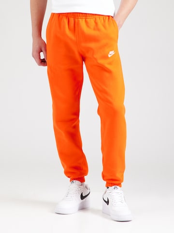 Nike Sportswear Tapered Housut 'Club Fleece' värissä oranssi: etupuoli