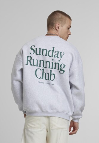 Another Cotton Lab Tréning póló 'Sunday Running Club' - szürke: elől