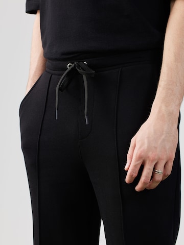 Tapered Pantaloni di ABOUT YOU x Rewinside in nero