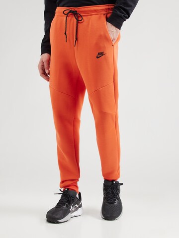 Nike Sportswear Tapered Παντελόνι 'TCH FLC' σε πορτοκαλί: μπροστά