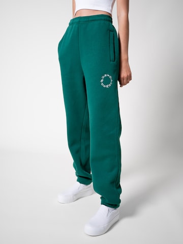 UNFOLLOWED x ABOUT YOU Tapered Broek 'BOLD' in Groen: voorkant