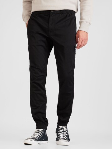 Calvin Klein Jeans - Tapered Pantalón chino en negro: frente