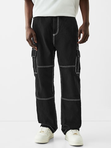 Bershka Loose fit Cargo trousers in Black: front