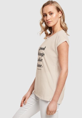 T-shirt 'Good Things Take Time' Merchcode en beige