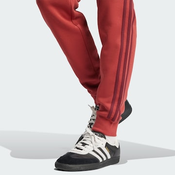 ADIDAS ORIGINALS - Tapered Pantalón 'Adicolor' en rojo