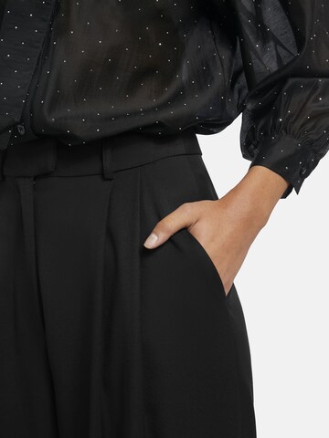 Nicowa Slimfit Anzughose 'ROSCIWO', weites Bein, Bundfalten, Model trägt Größe 34 in Schwarz