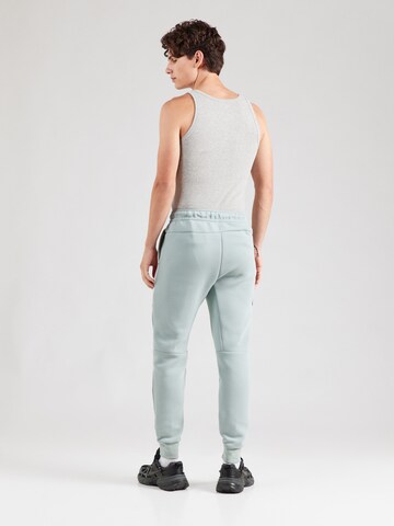 Tapered Pantaloni 'TCH FLC' de la Nike Sportswear pe verde