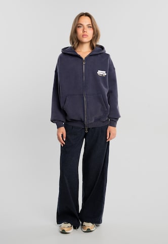 Another Cotton Lab - Sudadera con cremallera 'Community Clubhouse' en azul