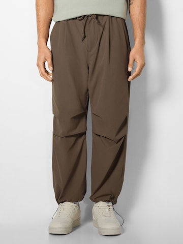 Bershka Tapered Trousers in Brown: front
