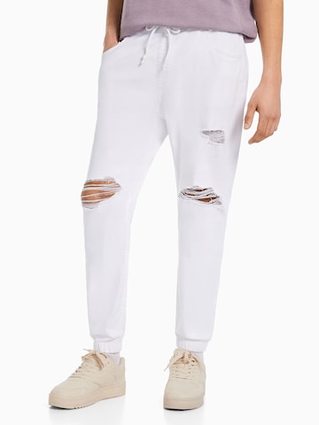 Bershka Tapered Jeans in White: front