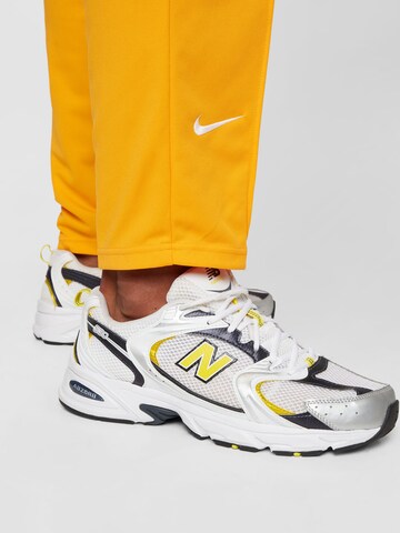 Tapered Pantaloni sportivi di NIKE in giallo