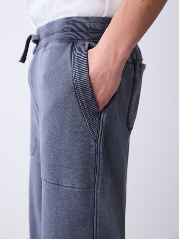 pilka Next Plačios klešnės Kelnės