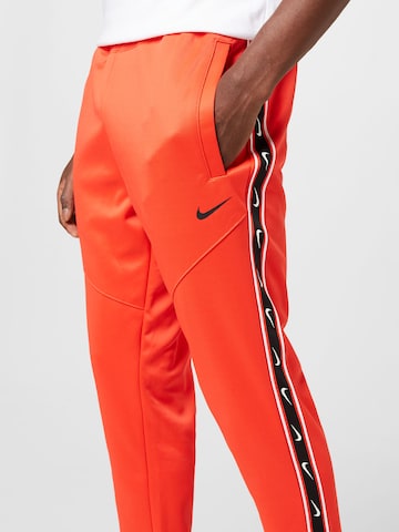 Tapered Pantaloni di Nike Sportswear in rosso