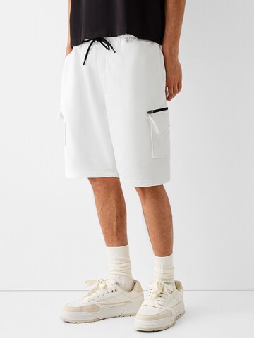 Bershka Loose fit Cargo trousers in White: front